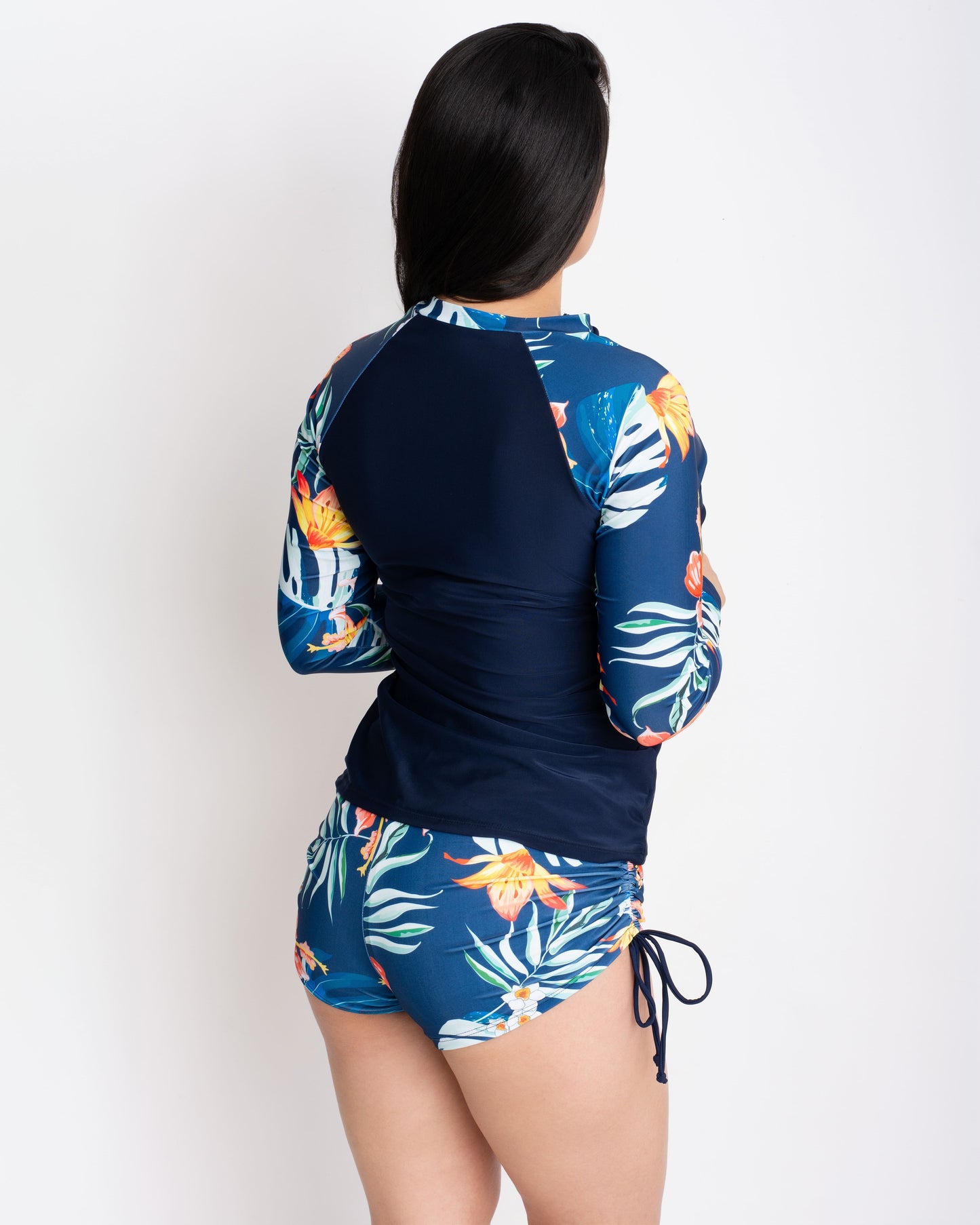 vista-posterior-mujer-en-traje-de-baño-tankini-blusa-con-short-azul-marino